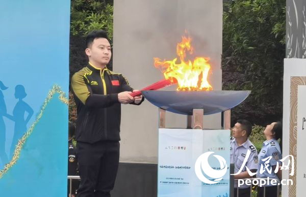 在活动开幕式上,冯喆点燃火炬。人民网记者 杨磊摄